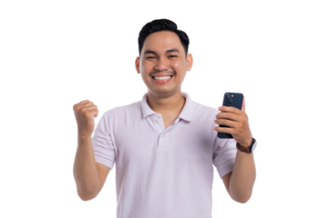 Smiling young Asian man celebrating success while holding smartphone with fist pump isolated on transparent background