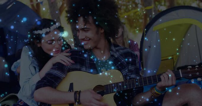 Campsite couple picking up guitar and strumming chord for travel with animated music notes floating