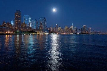 Fototapeta premium City skyline at night with moon reflecting in water and building lights shining