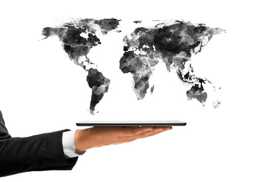 Business hand holding digital tablet with black watercolor world map sketch floating above on white background, symbolizing global technology concept. 