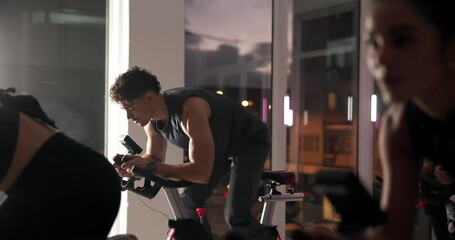Athlete group, bike and fitness in spin class for cardio improvement or performance at night. Exercise, stationary cycling and workout with intense people in gym together for late evening challenge
