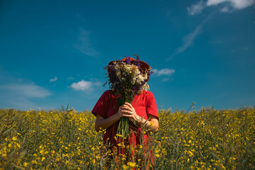 Trendy woman with stylish hat feeling free in the field with flowers