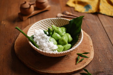  a bowl of klepon with coconut grated 