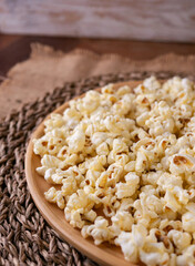 Butter salted popcorn on wooden table.