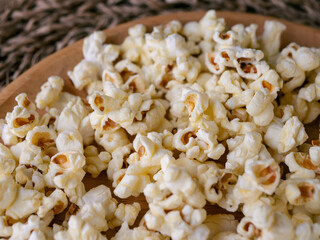 Butter salted popcorn on wooden table.
