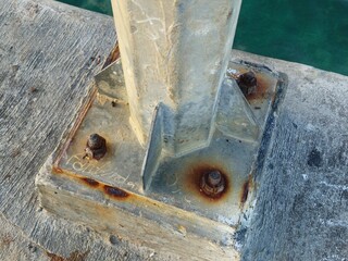 Rust stain on old metal pole and hex bolts