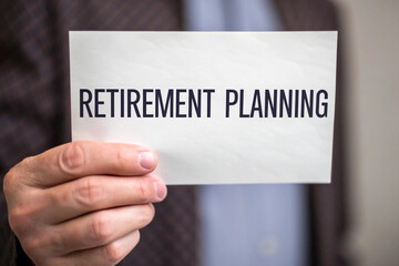 Close up of a person holding a sign with retirement planning text