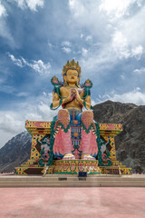Diskit Monastery, Front view of 108 feet tall statue of Maitreya Buddha in Nubra Valley, Ladakh, India, Buddha Statue with beautiful Himalayas and dramatic cloud in Nubra valley in the background