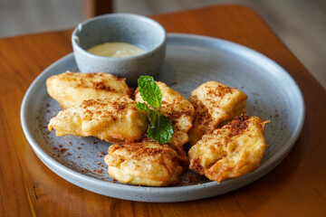 Crispy Fried Banana, Indonesia, captured on June 12, 2025. Traditional snack made from ripe bananas coated in crispy batter, topped with grated palm sugar for a sweet and crunchy finish.