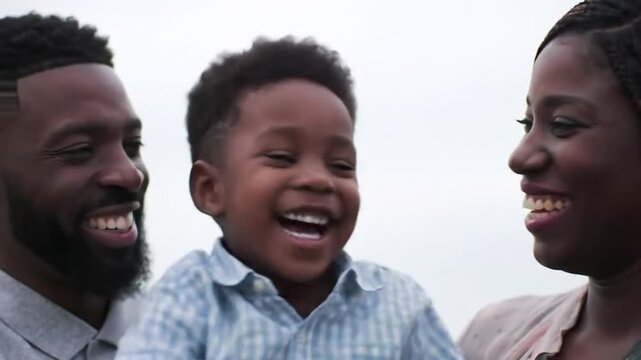 Happy African American Family Smiling in Close Up Against Sky With a Plaid Shirted Child