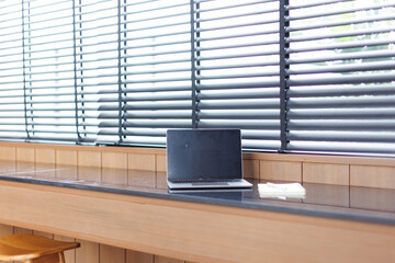 Laptop with blank copy space screen on table with stationery on table against white wall....