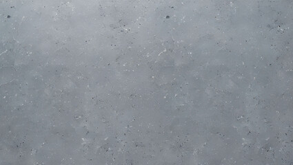 Obraz premium A gray textured surface with small dark and light specks scattered across the entire background area