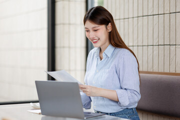  Portrait of young business woman using a calculator to check company finances and earnings and...