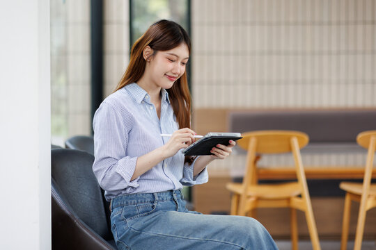 Portrait of young business asian woman using tablet in the cafe
