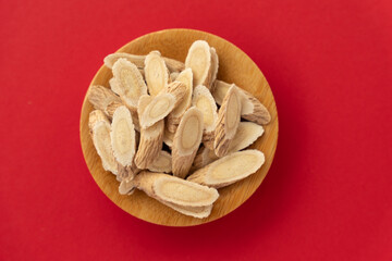 Astragalus membranaceus, a traditional Chinese medicine, on a red background