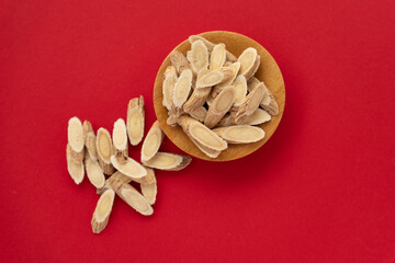 Astragalus membranaceus, a traditional Chinese medicine, on a red background