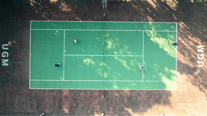 Aerial View of a Tennis Court with Players Engaging in a Game at UGM