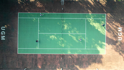 Aerial View of a Tennis Court at UGM During a Sunny Daytime Game