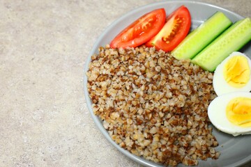 Buckwheat with boiled egg, cucumbers and tomatoes, breakfast