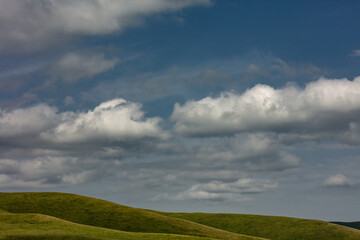clouds over green field