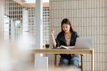 Business freelance young adult asian woman using laptop at cafe
