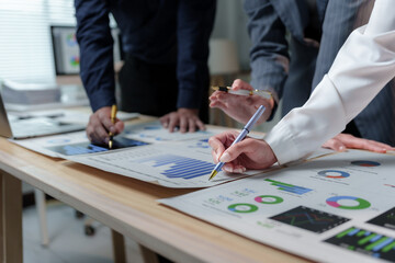Business people working together discussing financial charts and graphs showing market growth at corporate meeting