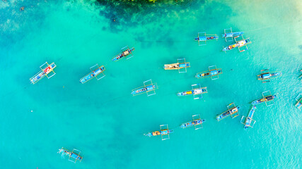 Aerial View of Numerous Traditional Boats Docked in a Vibrant Turquoise Lagoon on a Sunny Day