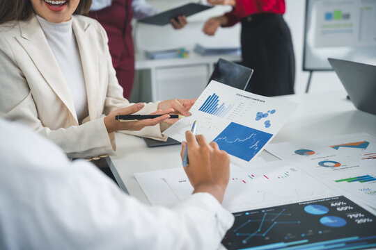 Business team analyzing financial charts and graphs showing market data during a meeting in the office