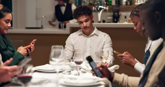 Ignore, antisocial and man with friends in restaurant with phone for social media or online addiction. Sad, diner and lonely person with people on smartphone for exclusion, neglect and annoyed