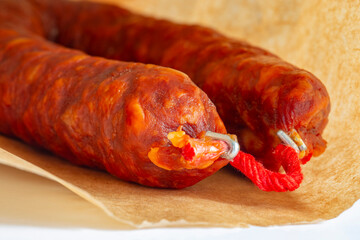Spanish Chorizo spicy sausage in a brown paper bag background. Environmetally friendly eco biodegradable packaging concept.