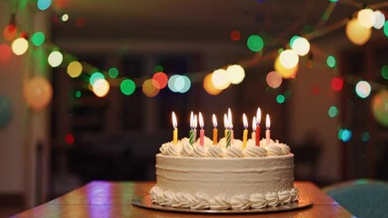 Bright Dessert for Child's Birthday Party on Background of Bokeh Light Bulbs Garlands. Birthday Cake with Burning Candles, chocolate glaze is Rotating on Stand on Table in House. Family. Childhood - Powered by Adobe
