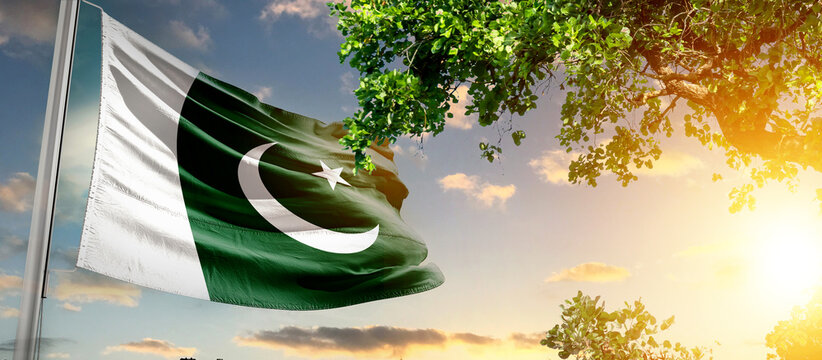 Pakistan flag waving in the sky. A couple hike and enjoy a break look at the top of the mountain adventure travel. Pakistan national flag for independence day.