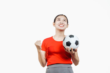 Confident young Asian woman in vibrant red shirt stands against white background, cheering joyfully...