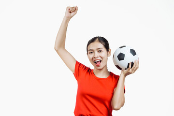 Confident young Asian woman in vibrant red shirt stands against white background, cheering joyfully...