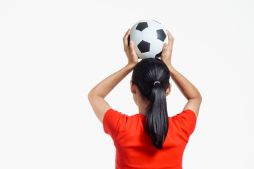 Confident young Asian woman in vibrant red shirt stands against white background, cheering joyfully...