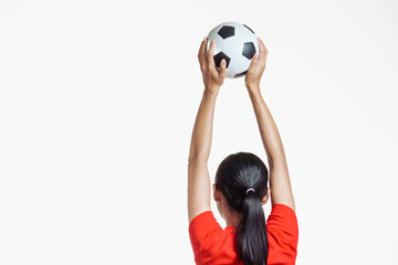 Confident young Asian woman in vibrant red shirt stands against white background, cheering joyfully...
