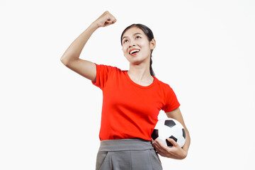Confident young Asian woman in vibrant red shirt stands against white background, cheering joyfully...