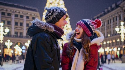 Young romantic couple is having fun outdoors in big winter city before Christmas. Enjoying spending time together in New Year Eve. Two lovers are hugging and kissing in Saint Valentine's Day. xmas - Powered by Adobe