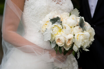 Naklejka premium Bride Holding Coastal Bouquet Beside Groom in Newport