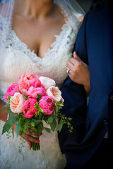 Bride Holding Pink Bouquet Arm-in-Arm with Groom in Navy Suit