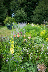 Lush Summer Garden with Wildflowers and Green Bench