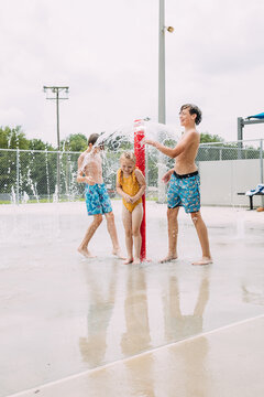 Energetic kids playing together at urban splash pad