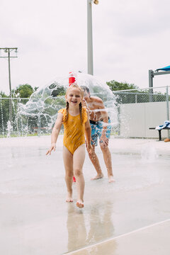 Spirited children playing in city splash pad during summertime