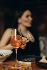 Elegant Woman at Dinner Table with Refreshing Rosé Drink and Delicious Cuisine