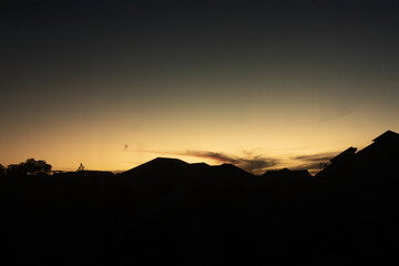 Silhouette of Rooftops Under a Vibrant Sunset Sky