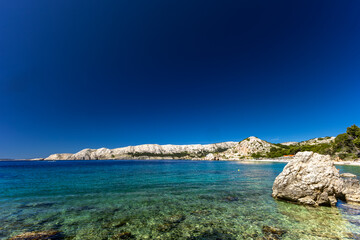 Jablanova Beach on the island of KRK in Croatia, blue trail leading to an empty pebble beach,