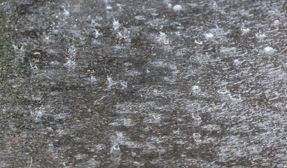 Obraz premium A wet sidewalk with raindrops falling on it