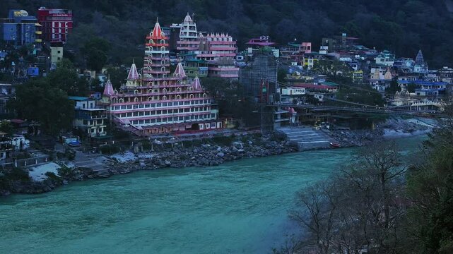 Drone shot of Rishikesh City. Aerial view of the beautiful holy river Ganga, Lakshman Jhula bridge, and Tera Manzil Temple, Trimbakeshwar in Rishikesh. A sacred town and travel destination in India.