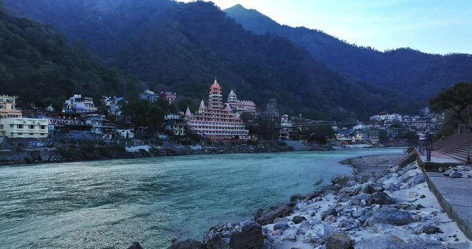 Drone shot of Rishikesh City. Aerial view of the beautiful holy river Ganga, Lakshman Jhula bridge, and Tera Manzil Temple, Trimbakeshwar in Rishikesh. A sacred town and travel destination in India.