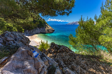 Jablanova Beach on the island of KRK in Croatia, blue trail leading to an empty pebble beach,